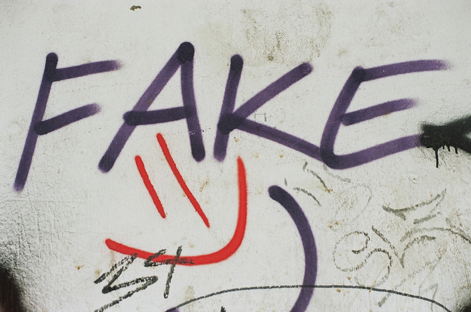 Graffiti on a wall that reads fake