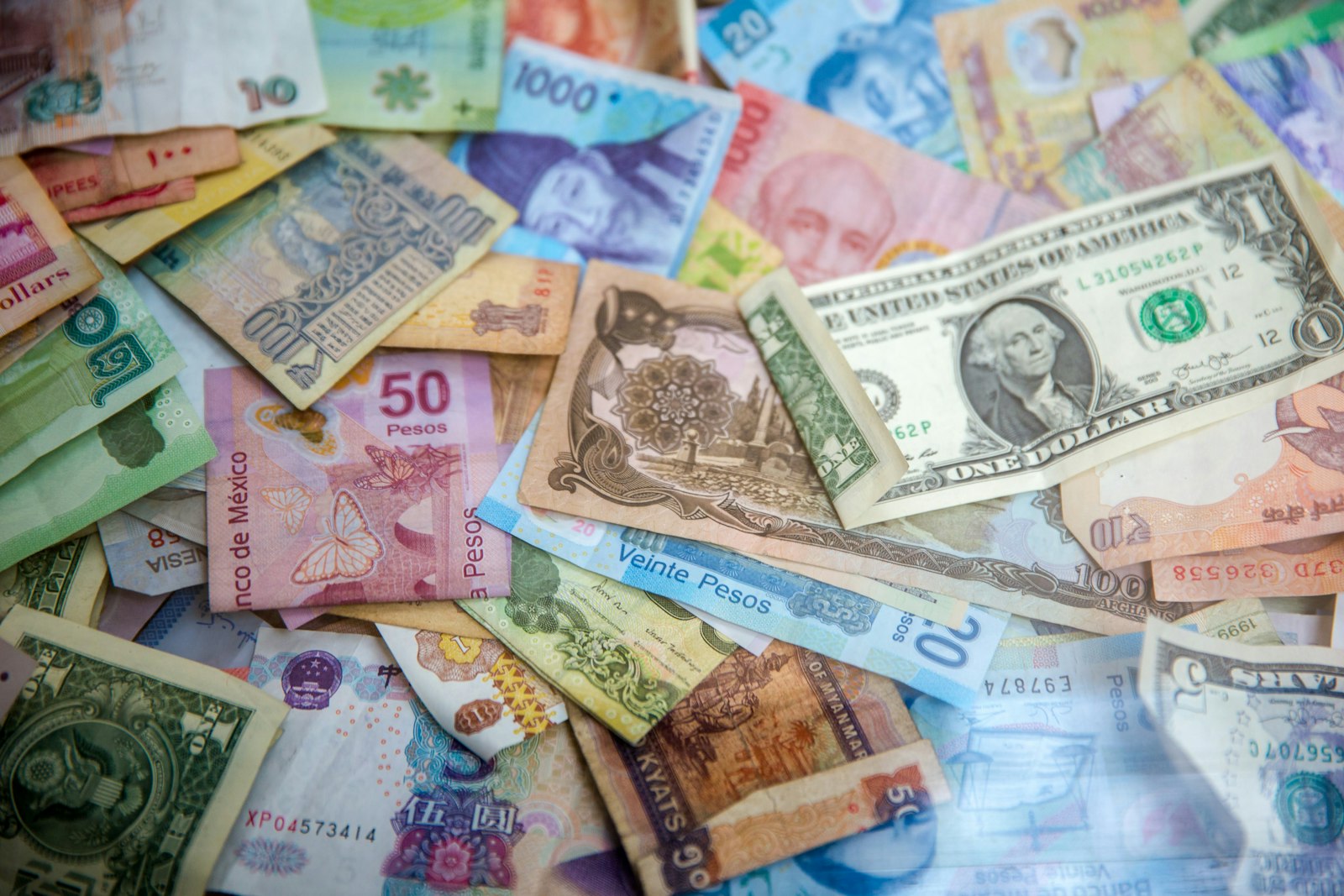 Banknotes from several countries scattered across a table